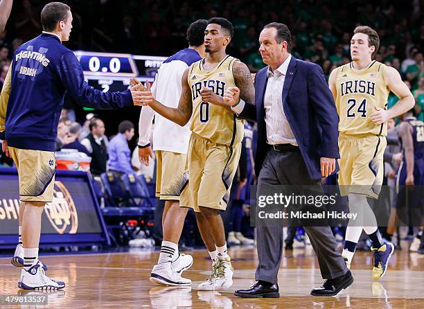 Head coach Mike Brey of the Notre Dame Fighting Irish and members of the team walk back to the bench during a timeout against the Pittsburgh Panthers...