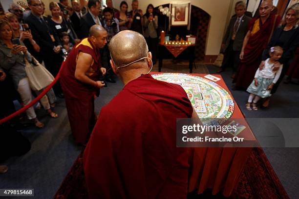 The 14th Dalai Lama, center, looks at the sand mandala created in honor of His Holiness the Dalai Lama's 80th birthday and Global Compassion Summit...