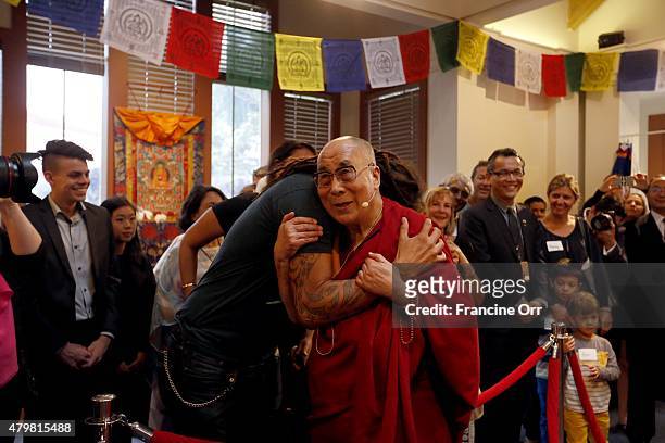 Michael Franti, left, musician and poet, greets the 14th Dalai Lama, right, during a private event blessing a sand mandala. The sand mandala was...