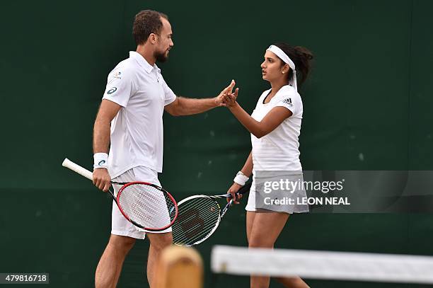 India's Sania Mirza talks with partner Brazil's Bruno Soares touches hands between points against Croatia's Marin Draganja and Ana Konjuh in their...