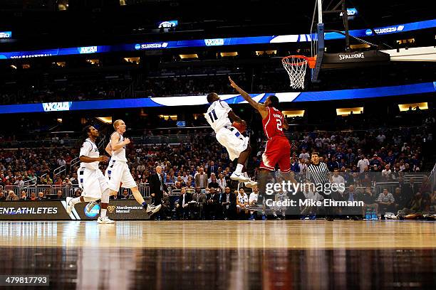 Mike McCall Jr. #11 of the Saint Louis Billikens takes a shot against Anthony Barber of the North Carolina State Wolfpack during the second round of...