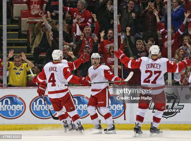 Tomas Tatar of the Detroit Red Wings scores in the third period and celebrates with his teammates Jakub Kindl and Kyle Quincey during the game...