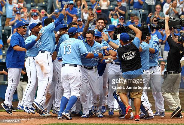Paulo Orlando of the Kansas City Royals is congratulated by teammates at home plate after hitting a walk-off grand slam in the bottom of the 9th...