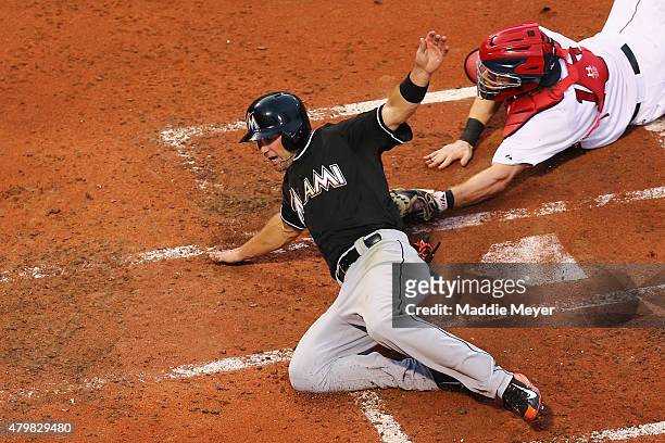 Cole Gillespie of the Miami Marlins scores a run past Ryan Hanigan of the Boston Red Sox in the third innning during the third inning at Fenway Park...