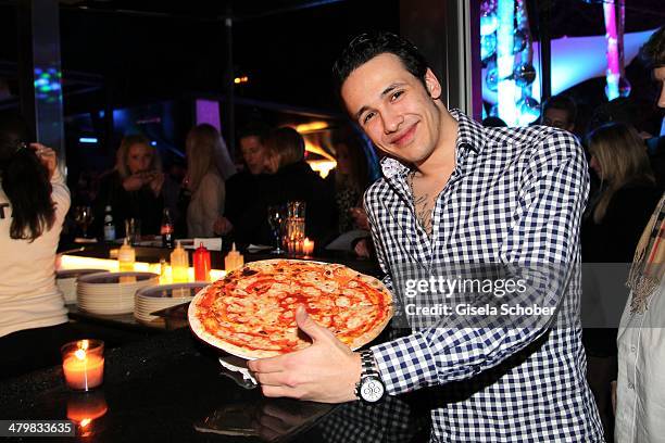 Marvin Herzsprung with a H'ugo's Pizza attends the 30 year anniversary celebration of the club P1 on March 20, 2014 in Munich, Germany.