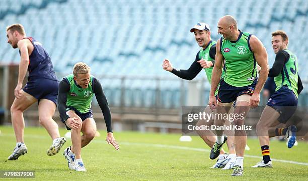 James Podsiadly of the Crows, Taylor Walker of the Crows and Nathan Van Berlo of the Crows react during an Adelaide Crows AFL training session at...