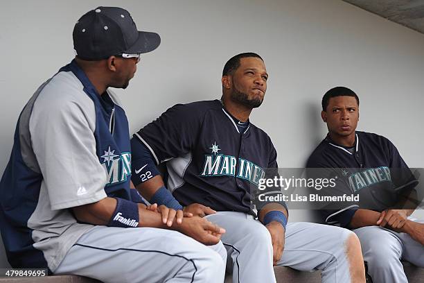 Endy Chavez and Robinson Cano of the Seattle Mariners sit in the dugout during the game against the Chicago Cubs at Cubs Park on March 20, 2014 in...