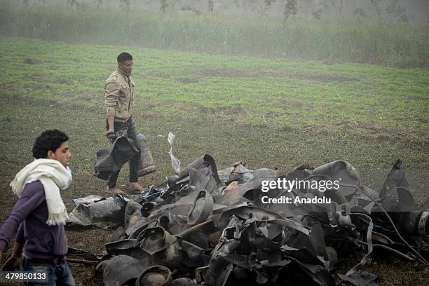 The people pick up the surrounding gas cylinders pieces. Egyptian fire fighters brought a fire at a gas cylinders storage under control in Giza,...