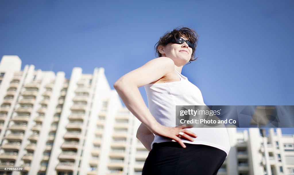 Pregnant woman in front of buildings