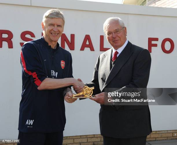 Chairman Sir Chips Keswick presents Arsene Wenger with a gold cannon to commemorate his 1000th game as Arsenal manager at London Colney on March 21,...