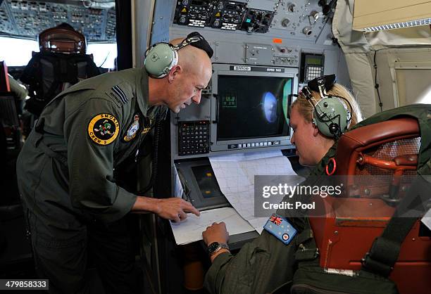 Flight Leuitenant Neville Dawson discusses the search area with Flight Officer Brittany Sharpe on board a Royal Australian Airforce AP-3C Orion from...