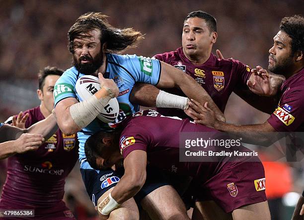 Aaron Woods of the Blues is tackled during game three of the State of Origin series between the Queensland Maroons and the New South Wales Blues at...