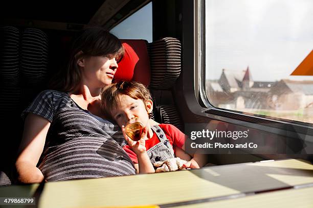 mother and her young son in train - familie in der bahn stock-fotos und bilder