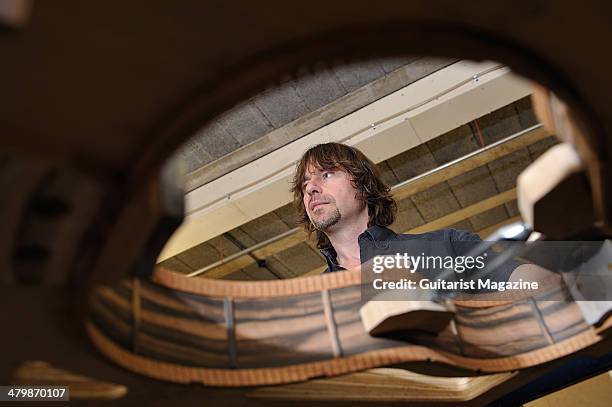 British luthier Patrick James Eggle clamps the sides of an acoustic guitar together at his workshop in Oswestry, photographed during a shoot for...