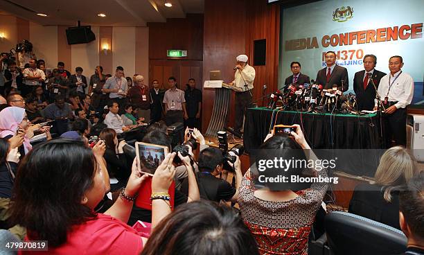 Members of the media take photographs of, from right, Ahmad Jauhari Yahya, chief executive officer of Malaysian Airline System Bhd. , Anifah Aman,...