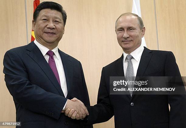 Russian President Vladimir Putin shakes hands with his China's counterpart Xi Jinping during their meeting in Ufa on July 8, 2015 ahead of the start...