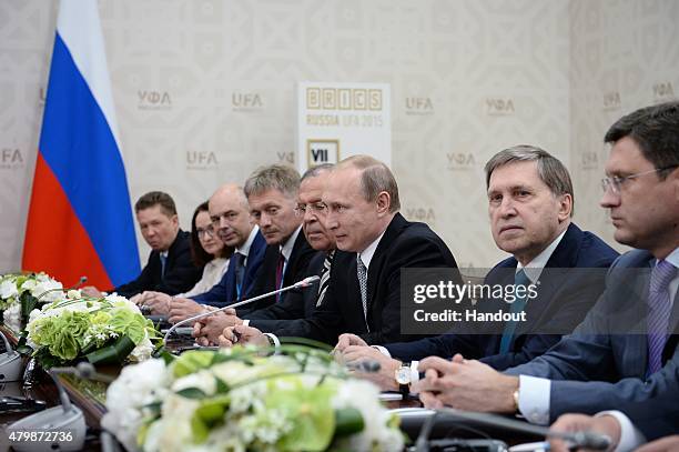 In this handout image supplied by Host Photo Agency / RIA Novosti, President of the Russian Federation Vladimir Putin attends a meeting with...