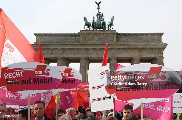 Demonstrators hold signs reading 'Not a Wish But a Right to More!' in front of the Brandenburg Gate during the 'Equal Pay Day' demonstration on March...