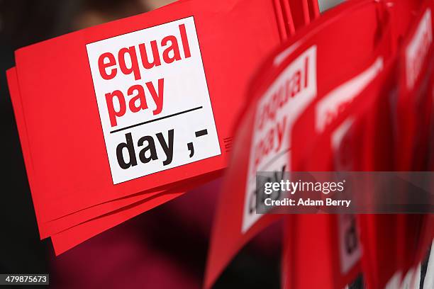 Flags reading 'Equal Pay Day' are seen during the 'Equal Pay Day' demonstration on March 21, 2014 in Berlin, Germany. The annual event recognizes the...