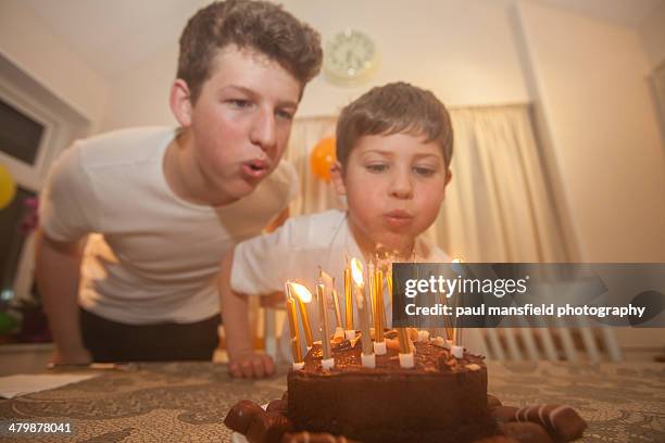 Brothers blowing out birthday candles