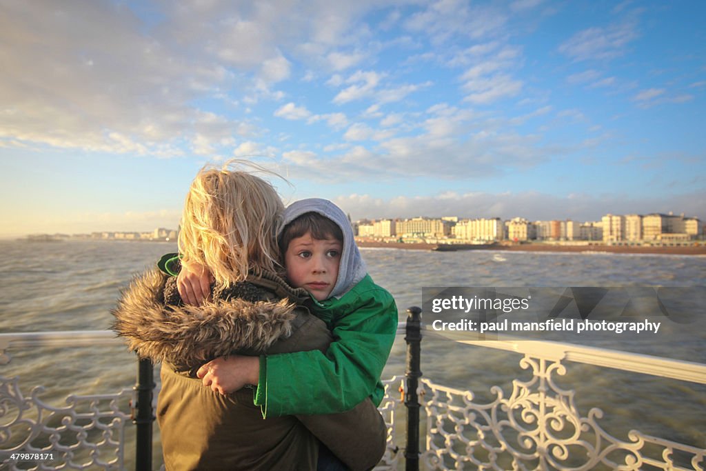 Boy hugs his Mum on Pier