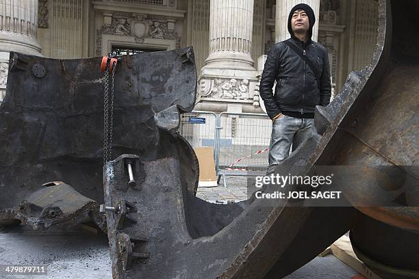 Chinese artist Liu Bolin attends the installation of his art creation, a giant fist sculpture "Iron First", at the Grand Palais museum in Paris on...