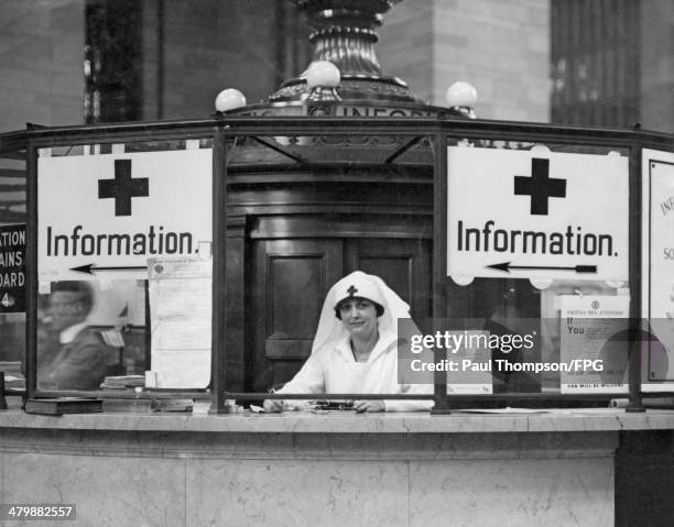 An American Red Cross nurse provides directions and information for enlisted men at Grand Central Station in New York City during World War I, circa...