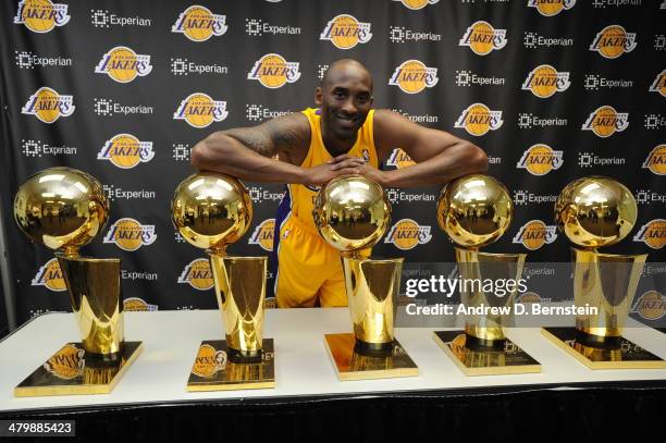 Kobe Bryant of the Los Angeles Lakers poses for a picture with his 5 NBA Championship trophies at STAPLES Center on March 20, 2014 in Los Angeles,...