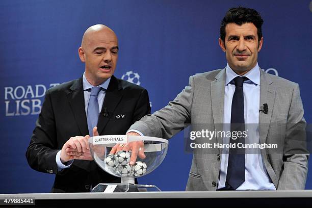 General Secretary Gianni Infantino and Ambassador for the final Luis Figo proceed to the UEFA Champions League 2013/14 season quarter-finals draw at...