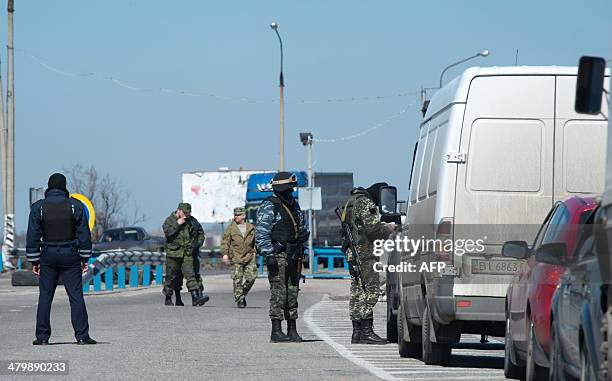 Russian forces check vehicles at a checkpoint in Henichesk district, on the road accross the Chongar strait, one of only two roads linking Crimea to...