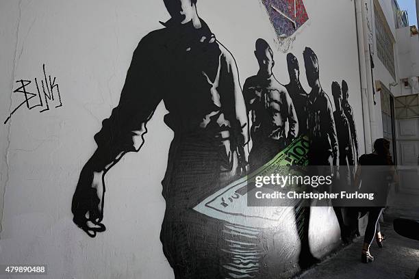 Woman walks past grafiti art called 'Death of Euro' by French street artist Goin at Athens School of Fine Art on July 8, 2015 in Athens, Greece....