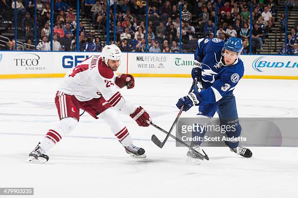 Keith Aulie of the Tampa Bay Lightning shots the puck against Kyle Chipchura of the Phoenix Coyotes during the third period at the Tampa Bay Times...