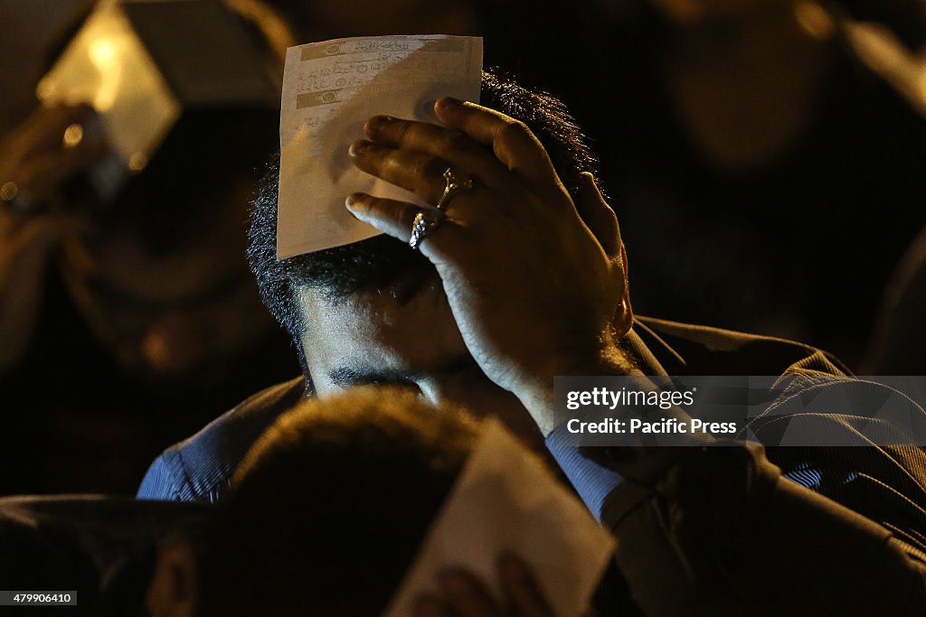 A young Azerbaijani muslim boy is holding the Quran on his...