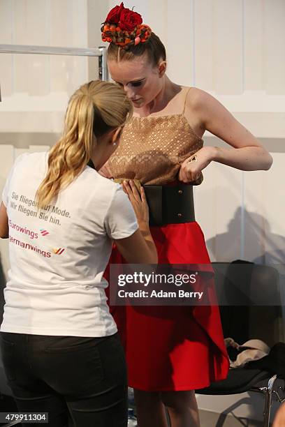 Volunteer helps prepare a model for the Rebekka Ruetz show during the Mercedes-Benz Fashion Week Berlin Spring/Summer 2016 at Brandenburg Gate on...