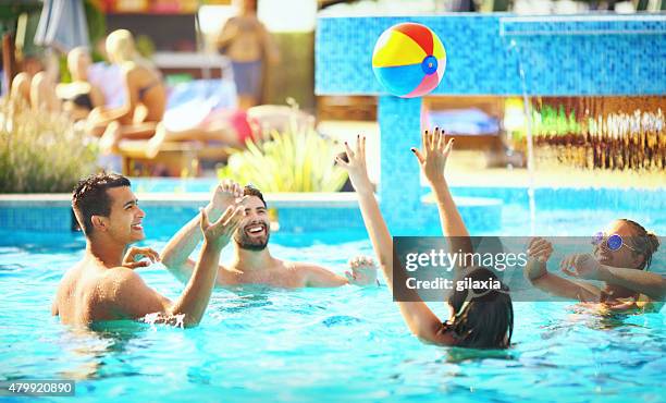 friends playing volleybay in a pool. - candid volleyball stock pictures, royalty-free photos & images