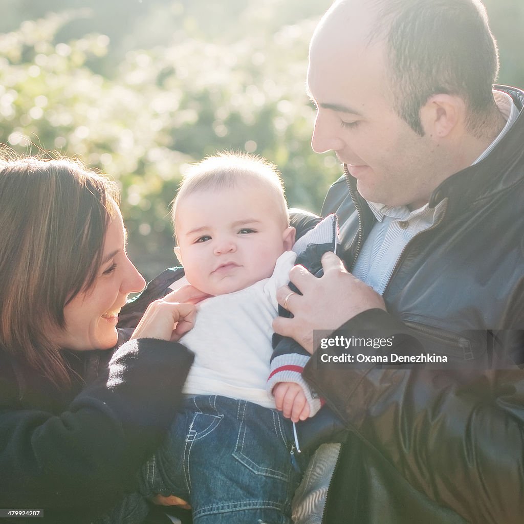 Mother and father with small baby boy, square imag