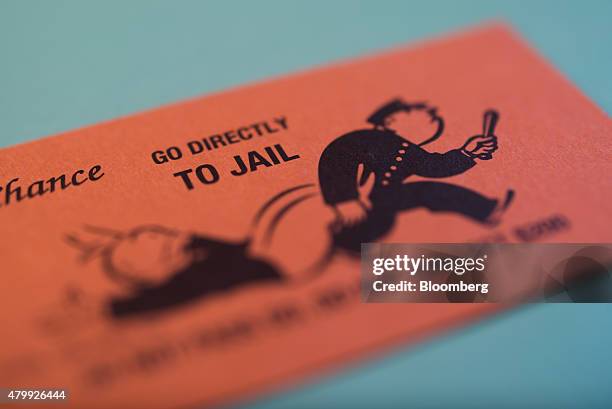 Go Directly To Jail" Chance card is arranged on a Hasbro Inc. Monopoly board game for a photograph taken with a tilt-shift lens in Oradell, New...