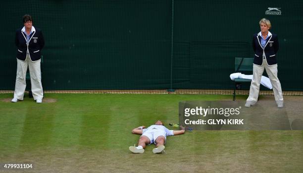 France's Richard Gasquet lays on the floor after beating Switzerland's Stan Wawrinka during their men's quarter-finals match on day nine of the 2015...