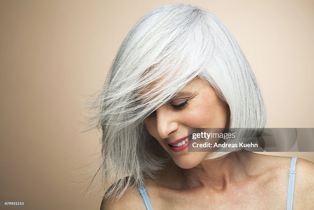 Woman with a silvery,grey bob looking down.