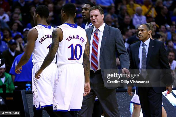 Head coach Bill Self of the Kansas Jayhawks talks with Wayne Selden Jr. #1 and Naadir Tharpe of the Kansas Jayhawks against the Eastern Kentucky...