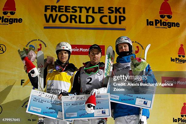 Second place Mikael Kingsbury of Canada, first place Alex Bilodeau of Canada and third place Benjamin Cavet of France stand on the podium during the...