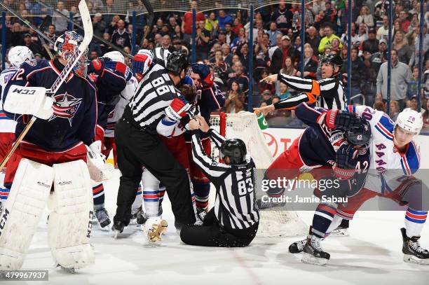 Chris Kreider of the New York Rangers pulls Artem Anisimov of the Columbus Blue Jackets away as linesmen Mike Cvik and Matt MacPherson attempt to...