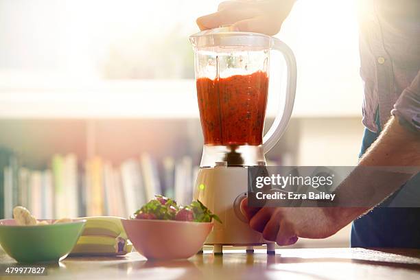 man making a smoothie at home. - ミキサー ストックフォトと画像