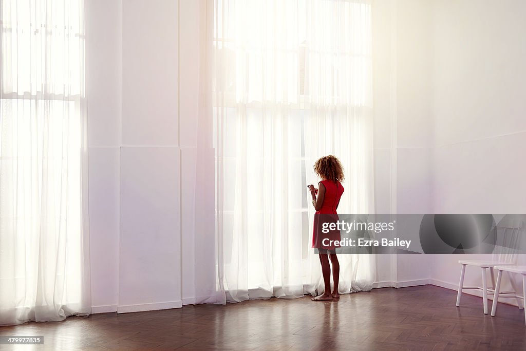 Mixed race woman using her phone at home.