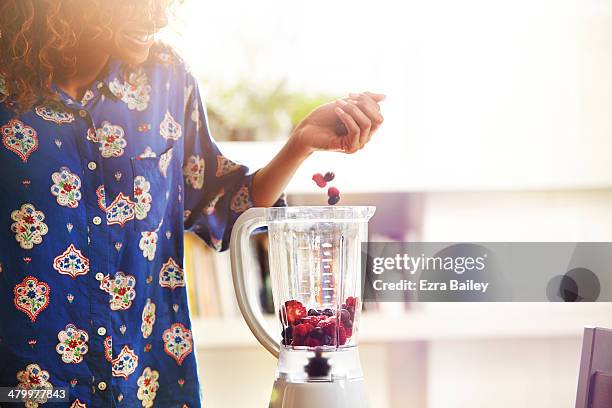 woman making a smoothie at home. - berries and hand stock pictures, royalty-free photos & images