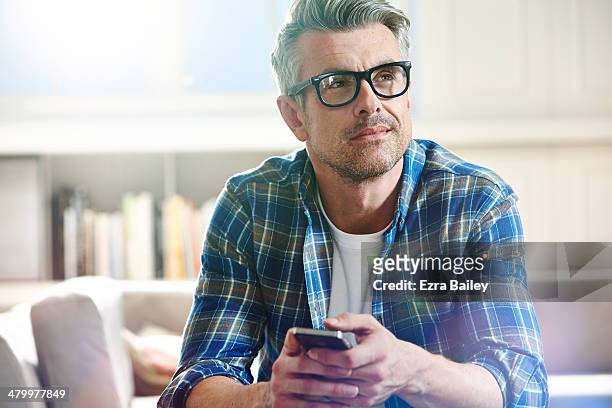 thoughtful man relaxing at home. - decisions fotografías e imágenes de stock