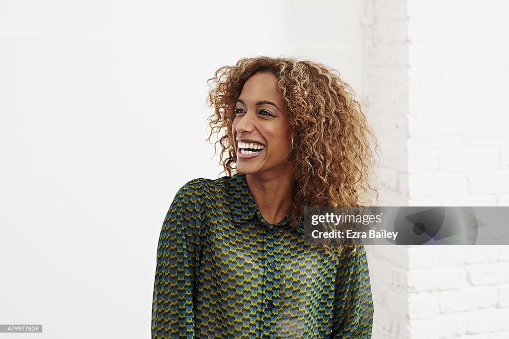 Mixed race woman laughing in an office.