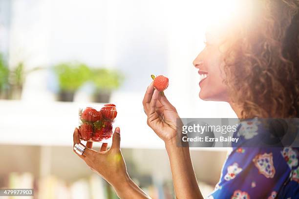 woman eating strawberries at home. - 5 am tag stock-fotos und bilder