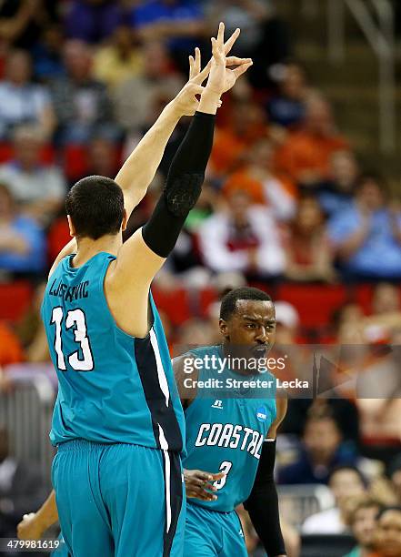 Uros Ljeskovic and Josh Cameron of the Coastal Carolina Chanticleers celebrate a three-pointer in the first half against the Virginia Cavaliers...