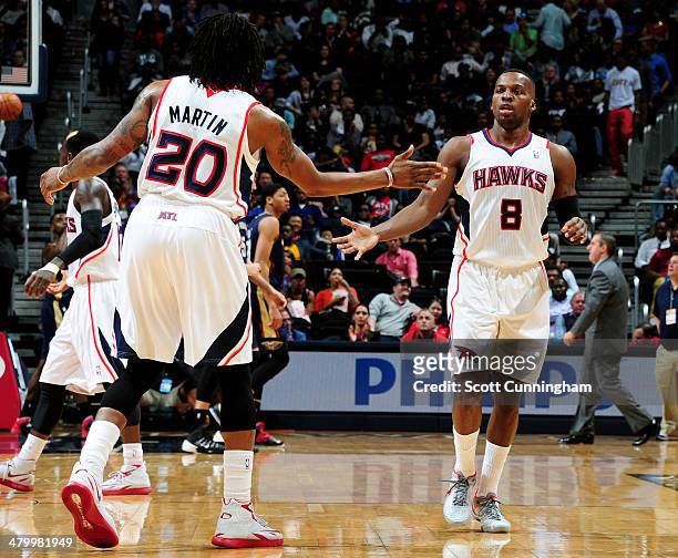 Shelvin Mack and Cartier Martin of the Atlanta Hawks celebrate during a game against the New Orleans Pelicans on March 21, 2014 at Philips Arena in...